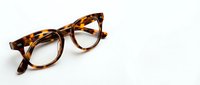 Stylish tortoiseshell eyeglasses with round frames on clean white background, isolated for design projects and optical fashion concepts.