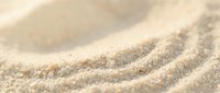 Soft golden sand dunes with gentle curves and natural texture patterns creating peaceful desert landscape for relaxation and meditation backgrounds.