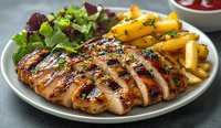 Grilled chicken breast sliced and served with golden french fries and fresh garden salad on white plate, close up view showing juicy meat texture and grill marks.