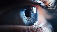 Extreme macro shot of human eye with blue iris, detailed view of eyelashes and cornea in dramatic lighting, showing intricate patterns and reflections.