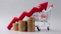 Rising costs shown through stacked gold coins with upward red arrow and shopping cart, illustrating inflation and consumer price increases in retail market.