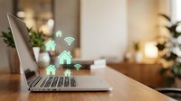 Smart home automation concept with laptop displaying connected house icons and wifi symbols on wooden desk in modern living room interior.