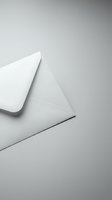 White envelope partially opened on gray background for business correspondence and mailing concepts.
