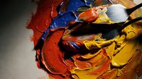 Close-up of vibrant oil paint palette with mixed colors and brushes for artistic projects and creative design work.