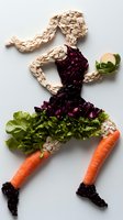 Dancing figure made from fresh vegetables and mushrooms on white background. Ballerina silhouette created with sliced mushrooms, red cabbage, lettuce and carrots.