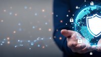 Businessman hand holding digital globe with cybersecurity shield and padlock icons representing global data protection and network security solutions.