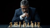 Mature businessman in navy suit contemplating chess strategy, focused on wooden pieces against dark background, portraying leadership and decision making.