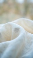 Close-up of soft, lightweight linen fabric with natural texture and gentle folds, suitable for textile design, fashion backgrounds, and material sourcing.