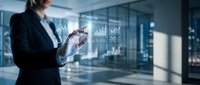 Businesswoman in dark suit interacting with holographic data analytics and financial charts in modern office environment, representing digital transformation and business intelligence technology.