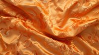 Luxurious peach and orange silk fabric with floral jacquard pattern creates elegant waves and folds, showcasing rich textile texture and light reflection.