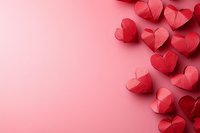 Red paper hearts arranged on pink background creating romantic border composition, suitable for Valentine's Day cards, wedding invitations and love messages.