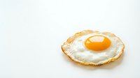 Fresh fried egg with golden yolk and crispy edges isolated on white background for breakfast cooking and culinary design projects.