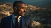 Professional businessman in elegant suit gazing thoughtfully at sunset landscape, corporate leadership and success concept for business presentations.