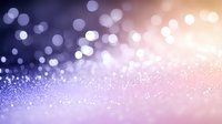 Dreamy purple and pink bokeh background with glowing particles and soft focus light effects creates magical atmosphere for festive designs and celebrations.