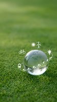 Glass sphere on green grass with eco-friendly icons representing renewable energy, sustainability and environmental protection for Earth Day campaigns.