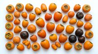 Ripe medlar fruits and dark persimmons arranged on white background, overhead view. Suitable for food photography, culinary blogs, recipe websites, and healthy eating content.