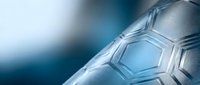 Close-up of soccer ball surface with hexagonal panels and stitching details against blurred blue background, suitable for sports marketing and athletic content.