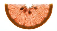 Sliced grapefruit half showing pink flesh and detailed segment structure on white background, suitable for food and beverage design projects.