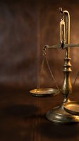 Vintage brass scales of justice on wooden surface with warm lighting for legal and law firm concepts.
