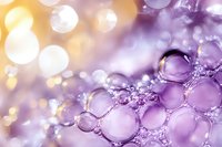 Purple soap bubbles with golden bokeh lights creating dreamy abstract background for cosmetics beauty products and spa wellness designs.