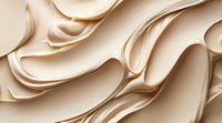 Luxurious cream-colored satin fabric with elegant flowing waves and soft folds creating abstract patterns and textures in warm beige tones. Suitable for beauty and fashion backgrounds.