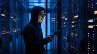 Asian female IT specialist working with tablet in modern server room with blue lighting and network equipment for technology solutions.