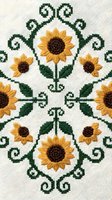 Sunflower embroidery pattern on linen fabric with green scrollwork, yellow blooms, and folk art symmetry, perfect for textile and craft design inspiration.