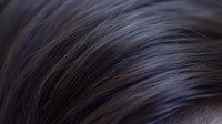 Close up macro shot of dark gray and black feathers showing detailed texture and natural pattern with soft selective focus creating abstract background effect.