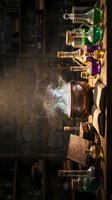 Magical alchemy laboratory with colorful potion bottles, smoking cauldron and mystical ingredients on wooden shelf creating enchanting atmosphere.