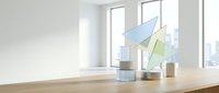 Modern minimalist office workspace with geometric paper planes on wooden desk near large windows showcasing urban cityscape for business presentations.