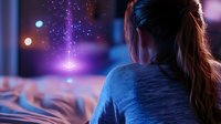Young woman with ponytail in blue sweater relaxing on bed looking at magical glowing lights and sparkles in cozy bedroom at night for dreams and fantasy concepts.