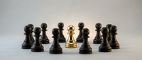 Golden chess pawn standing out among black pawns on white background, symbolizing leadership, uniqueness and strategic thinking in business concepts.