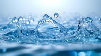 Dynamic water splash with droplets creating an arc shape against blurred blue background, macro photography capturing liquid motion and surface tension in crisp detail.
