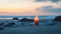 Solitary lit candle on sandy beach at sunset, creating peaceful ambiance against backdrop of ocean waves and colorful sky.