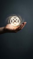 Male hand holding glowing infinity symbol with magical particles and light effects on dark background for business and technology concepts.