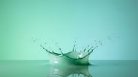 Water drop creating crown splash with droplets on turquoise surface against gradient background for refreshing beverage and purity concepts.