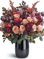 Luxurious floral arrangement featuring roses, astilbe, and seasonal blooms in burgundy, blush, and mauve tones arranged in a sleek black vase. Perfect for weddings, events, and home decor.