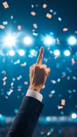 Business hand pointing upward with falling confetti and bright stage lights creating celebratory atmosphere for success presentations and achievement concepts.