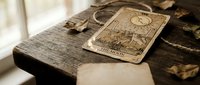 Vintage tarot cards spread on weathered wooden surface with mystical symbols and ornate designs for fortune telling and spiritual guidance practices.