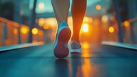 Close-up view of running shoes on female feet during evening jog, with blurred city lights creating atmospheric bokeh effect in background. Fitness lifestyle concept.