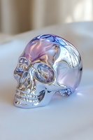 Metallic chrome skull with iridescent purple and blue reflections on white surface, dramatic side lighting creates mysterious atmosphere and highlights anatomical details.