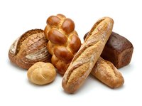 Assorted fresh baked bread loaves and rolls isolated on white background, including baguette, whole wheat, braided loaf, and round rolls for bakery and food design.
