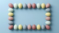 Pastel colored Easter eggs arranged in a rectangular frame on a light blue background, with copy space in the center for text or design.
