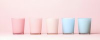 Row of five frosted glass tumblers in gradient pastel colors from pink to blue arranged on soft pink background for modern kitchen and dining decor.