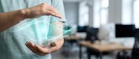 Professional businessman holding glowing digital hologram sphere in modern office workspace showcasing futuristic technology and innovation concepts.