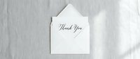 Elegant thank you card with calligraphy script tucked in a white envelope on a soft linen background, perfect for wedding and event stationery.