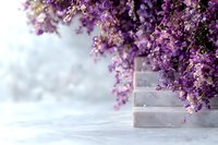 Purple lilac flowers cascading over marble surface in soft focus with dreamy bokeh background creates romantic spring atmosphere.