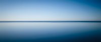 Serene ocean horizon with calm blue waters reflecting clear sky in minimalist seascape composition for meditation and wellness backgrounds.