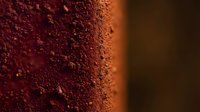 Rich cocoa powder texture with fine granules creating warm brown surface for baking, cooking, dessert preparation and culinary photography backgrounds.