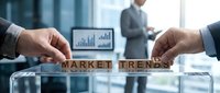 Business professionals analyzing market trends with wooden letter blocks spelling words on glass table in modern office conference room setting.